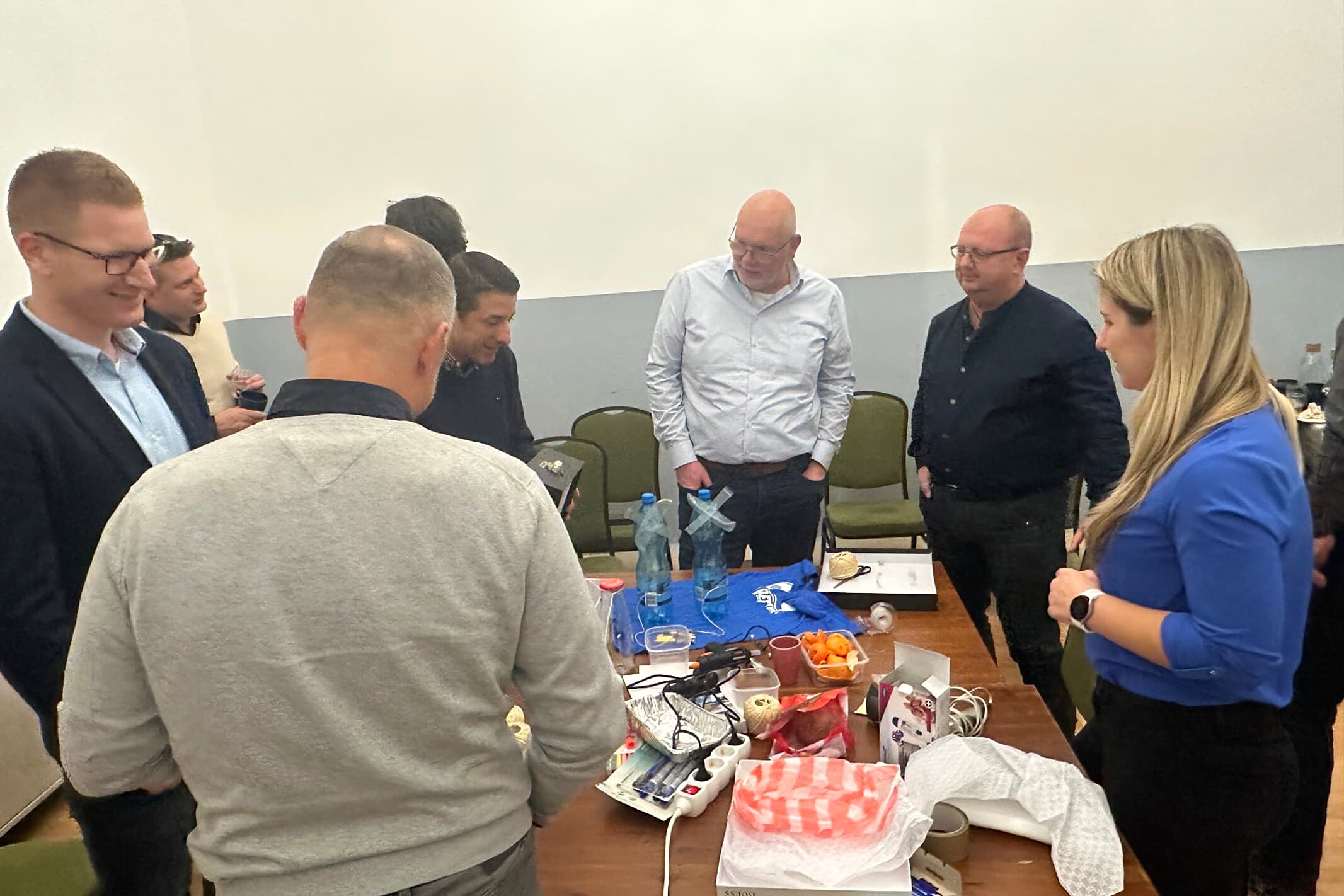 Mérnökök közösen dolgoznak egy csapatépítő workshop feladatán egy asztal körül